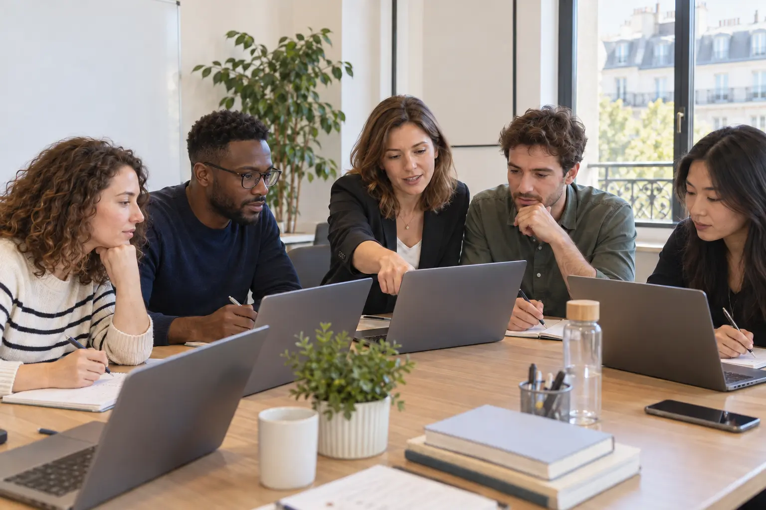 Une formatrice montre une manipulation sur son ordinateur à une équipe RH qui travaille sur ses propres ordinateurs